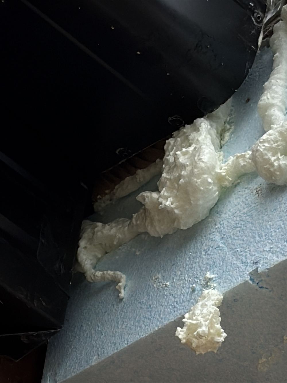 Timber framing left exposed beside an added cladding section, found during a pre-handover inspection in Berwick