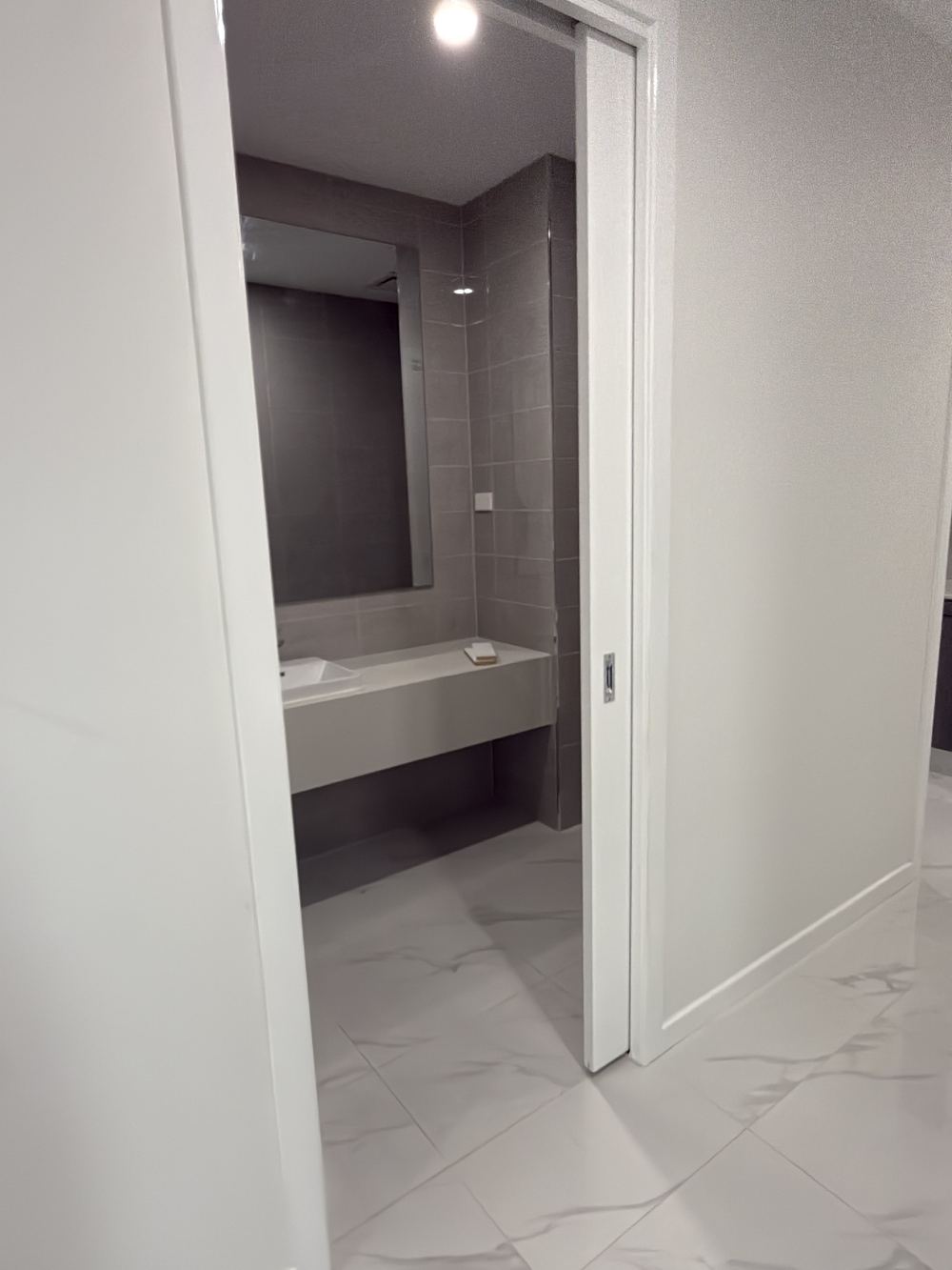 Powder room pocket door sliding fully into the wall with no privacy lock, found during a pre-handover inspection in Berwick